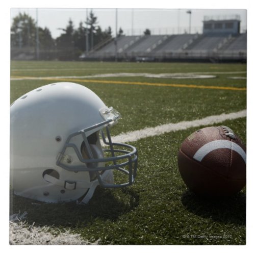 Football and football helmet on football field ceramic tile
