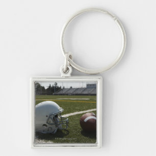 Football and football helmet on football field keychain