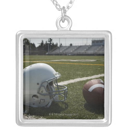 Football and football helmet on football field silver plated necklace