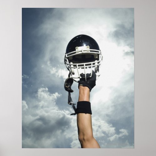 Football player holding helmet in air poster
