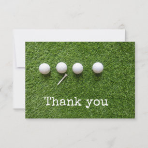 Four golf balls with tee on green grass thank you card