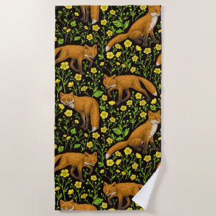 Foxes and buttercups on black beach towel