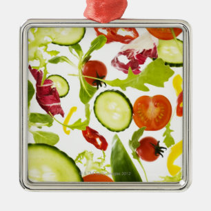 Fresh mixed salad vegetables falling to camera metal ornament