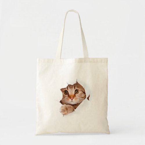 Funny cat in torn wallpaper hole tote bag