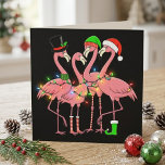 Funny Christmas Flamingos in Santa Hats and Lights Holiday Postcard<br><div class="desc">Funny Christmas Flamingos in Santa Hats and Lights features three pink flamingos dressed for the holidays with Santa hats, a top hat, striped socks, a green boot, and colorful string lights. The black background makes the bright festive details stand out and gives the artwork a bold seasonal look. This playful...</div>