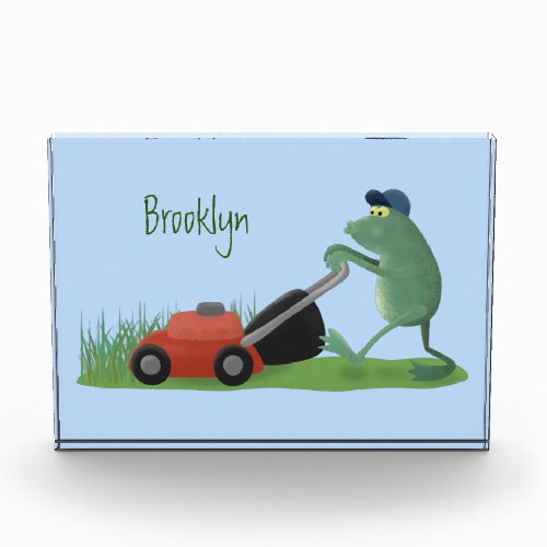 Funny green frog mowing lawn cartoon photo block