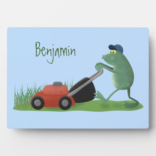 Funny green frog mowing lawn cartoon plaque
