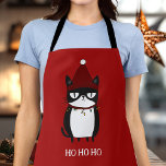 Funny Grouchy Cat Catmas Humor Apron<br><div class="desc">Get ready to cook up some holiday cheer with our Funny Grouchy Cat apron! Featuring a hilarious illustration of a cat tangled in Christmas lights, this apron is perfect for cat lovers and those who enjoy a good laugh in the kitchen. Ideal for holiday baking or festive cooking, it adds...</div>
