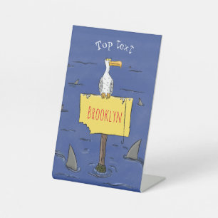 Funny sea bird circled by sharks cartoon pedestal sign