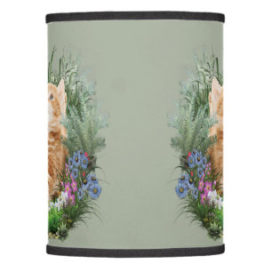 Ginger kitten playing with a butterfly lamp shade