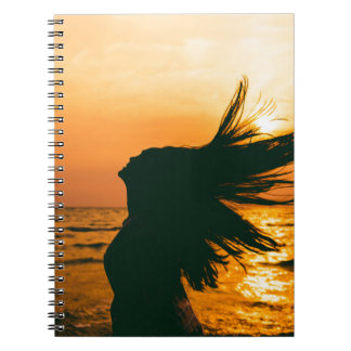 Girl silhouette, sea sunset, freedom. notebook