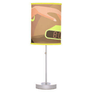 Girls hand pushing on alarm clock snooze button table lamp