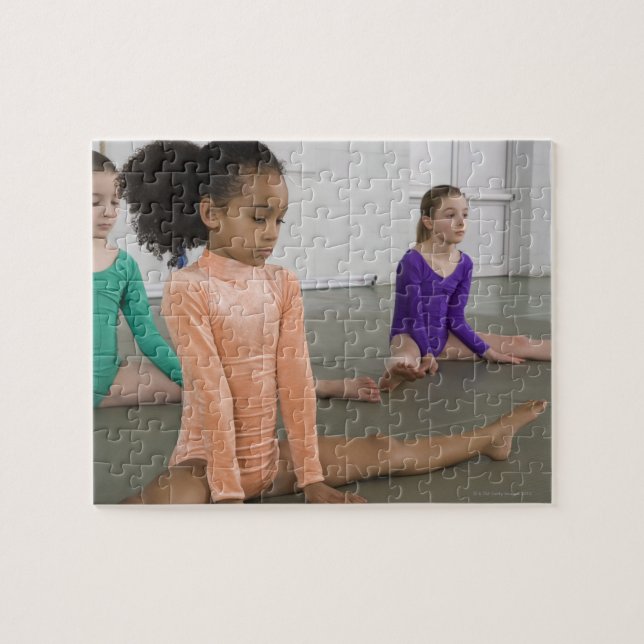 Girls stretching in gymnastics practice jigsaw puzzle (Horizontal)