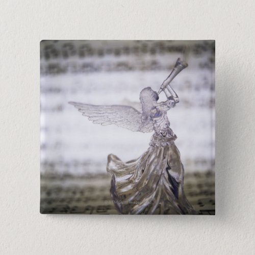 Glass angel playing trumpet and image of sheet button