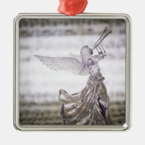 Glass angel playing trumpet and image of sheet metal ornament