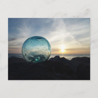 Glass float and sunset postcard