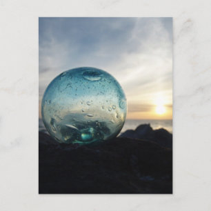 Glass float and sunset postcard