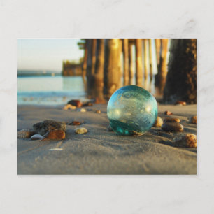 Glass float in front of pier postcard