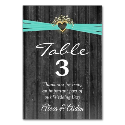 Gold Heart with Turquoise Ribbon On Gray Wood Table Number