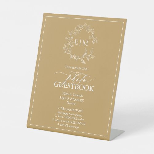 Gold Leafy Crest Monogram Photo Guestbook Pedestal Pedestal Sign - We're loving this trendy, modern gold wedding photo guestbook pedestal sign! Simple, elegant, and oh-so-pretty, it features a hand drawn leafy wreath encircling a modern wedding monogram. It is personalized in elegant typography, and accented with hand-lettered calligraphy. Finally, it is trimmed in a delicate frame. Veiw suite here: https://www.zazzle.com/collections/gold_leafy_crest_monogram_wedding-119668631605460589 Contact designer for matching products to complete the suite, OR for color variations of this design. Thank you sooo much for supporting our small business, we really appreciate it! 
We are so happy you love this design as much as we do, and would love to invite
you to be part of our new private Facebook group Wedding Planning Tips for Busy Brides. 
Join to receive the latest on sales, new releases and more! 
https://www.facebook.com/groups/622298402544171  
Copyright Anastasia Surridge for Elegant Invites, all rights reserved.