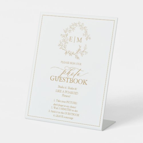 Gold Leafy Crest Monogram Photo Guestbook Pedestal Sign - We're loving this trendy, modern gold wedding photo guestbook pedestal sign! Simple, elegant, and oh-so-pretty, it features a hand drawn leafy wreath encircling a modern wedding monogram. It is personalized in elegant typography, and accented with hand-lettered calligraphy. Finally, it is trimmed in a delicate frame. Veiw suite here: https://www.zazzle.com/collections/gold_leafy_crest_monogram_wedding-119668631605460589 Contact designer for matching products to complete the suite, OR for color variations of this design. Thank you sooo much for supporting our small business, we really appreciate it! 
We are so happy you love this design as much as we do, and would love to invite
you to be part of our new private Facebook group Wedding Planning Tips for Busy Brides. 
Join to receive the latest on sales, new releases and more! 
https://www.facebook.com/groups/622298402544171  
Copyright Anastasia Surridge for Elegant Invites, all rights reserved.