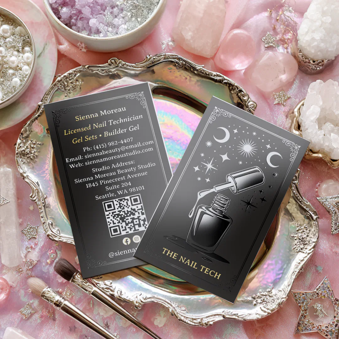 A black and silver business card with a bottle of nail varnish and celestial signs printed on the front cover. The card is sitting in a vintage gold trinket and the background is an overall pink and white beauty aesthetic.