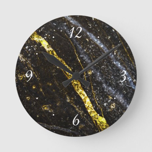 Gold sparkly line on black rock with clock face