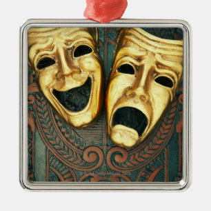 Golden comedy and tragedy masks on patterned metal ornament
