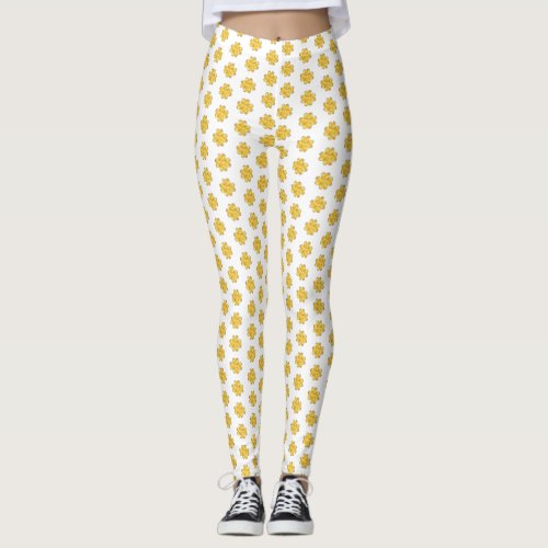 Golden four_leaf clovers on white leggings