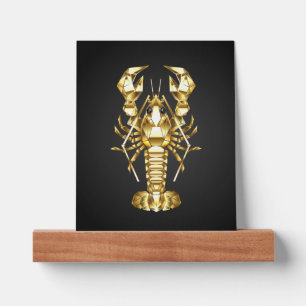 Golden polygonal lobster crawfish on black picture ledge