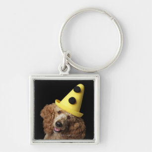 Golden Poodle Dog wearing a yellow clown hat Keychain