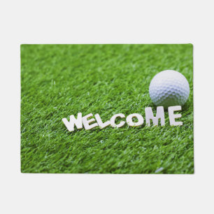 Golf ball aand welcome woed on grass doormat