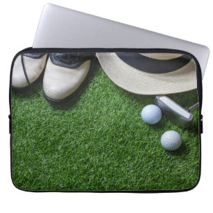 Golf ball and putter on green grass laptop sleeve