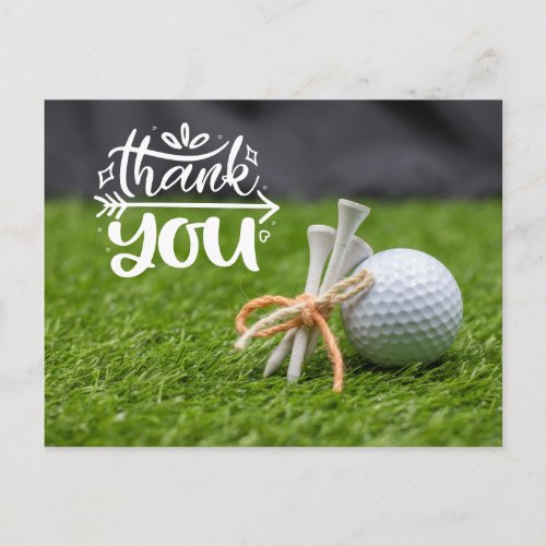 Golf ball and tee are on green grass thank you pos postcard