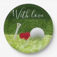 Golf ball and tee on green grass with love paper plates