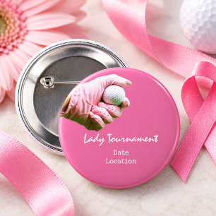 Golf ball is in lady golfer's hand on pink button