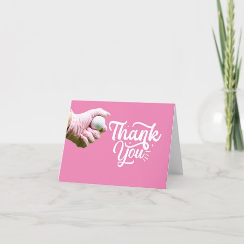 Golf ball is in lady golfers hand on pink  thank you card