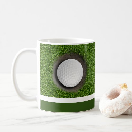 Golf ball is in the hole on green with name coffee mug