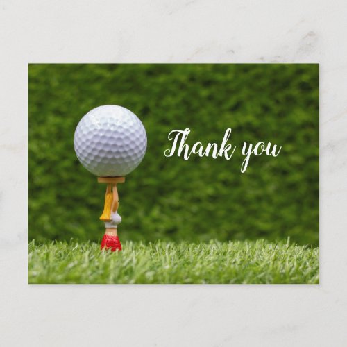 Golf ball is on the tee on green grass background postcard