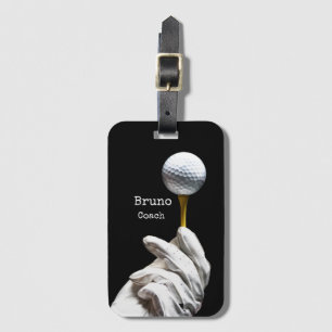 Golf ball on pin next to hole black background luggage tag
