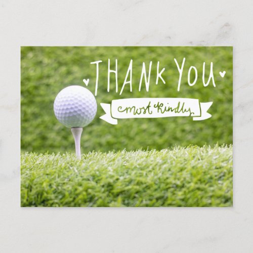 Golf ball on tee with green grass background postcard