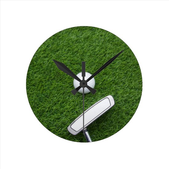 Golf ball with putter are on green grass round clock