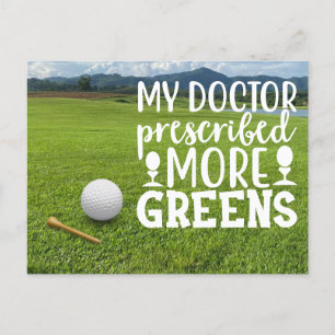 Golf ball with tee on green grass postcard