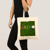 Golf ball with tees on green grass golf tote bag