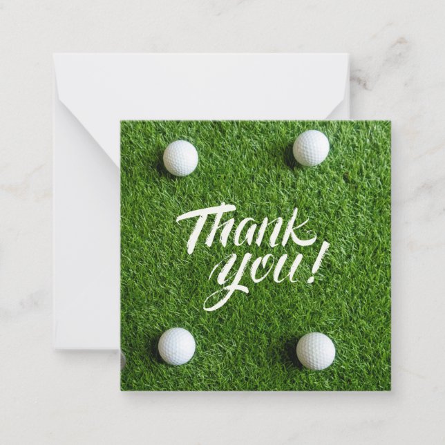 Golf ball with thank you word on green grass note card (Front)