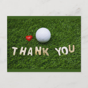 Golf ball with thank you word on green grass postcard