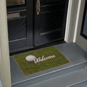 Golf ball with welcome for golfer on green grass doormat