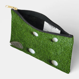 Golf balls are on green grass accessory pouch