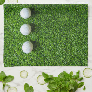 Golf Balls are on green grass Kitchen Towel