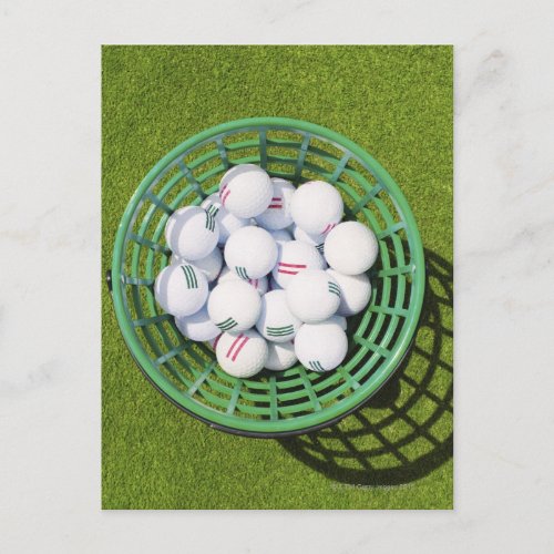 Golf balls in a basket sitting on short green postcard
